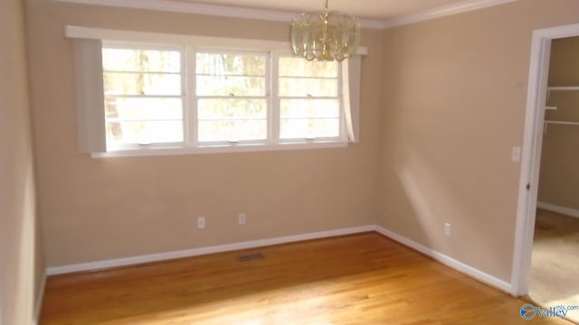 interior space with ornamental molding, hardwood / wood-style flooring, and a notable chandelier