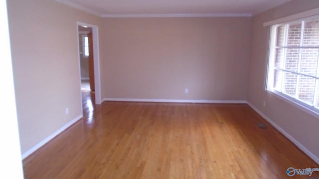 empty room with light wood-type flooring and ornamental molding