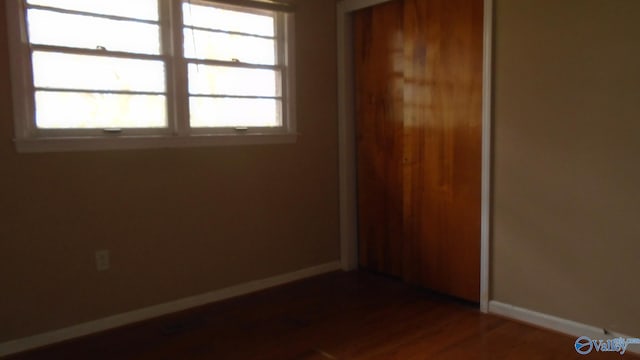 unfurnished bedroom with dark wood-type flooring