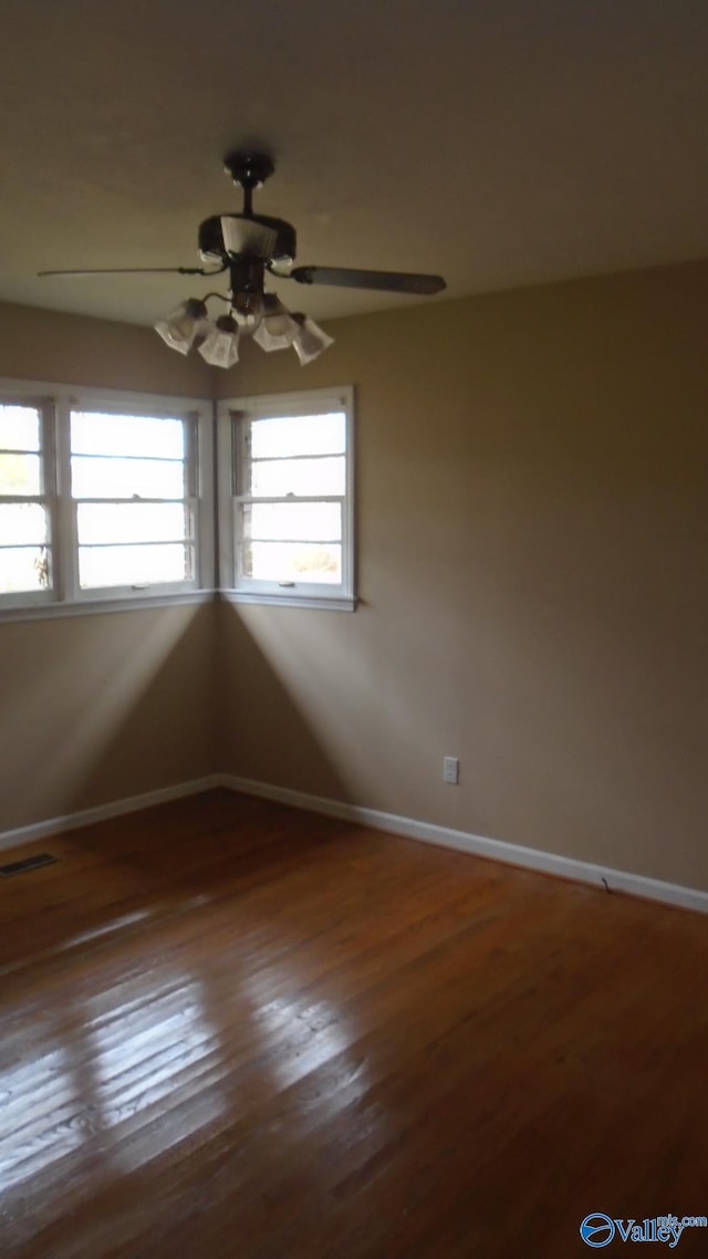 spare room featuring ceiling fan and dark wood-type flooring