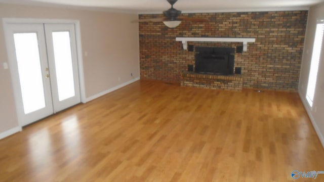 unfurnished living room with a wealth of natural light, french doors, and wood-type flooring