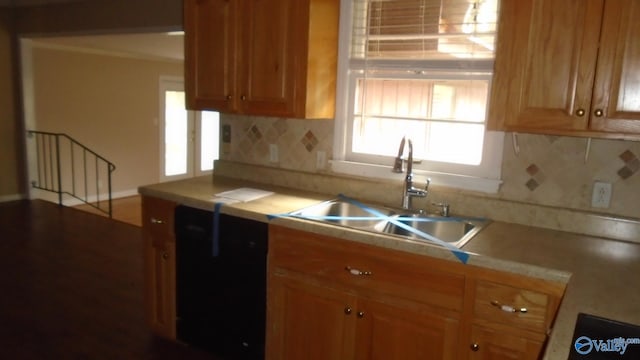 kitchen featuring dishwasher, decorative backsplash, and sink