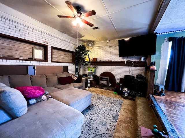 living room featuring ceiling fan, concrete flooring, and brick wall