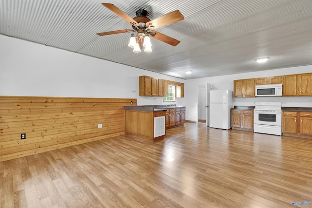 1073 6th St S, Sylvania, AL 35988 - kitchen with white appliances, dark countertops, brown cabinetry, a peninsula, and light wood-style flooring