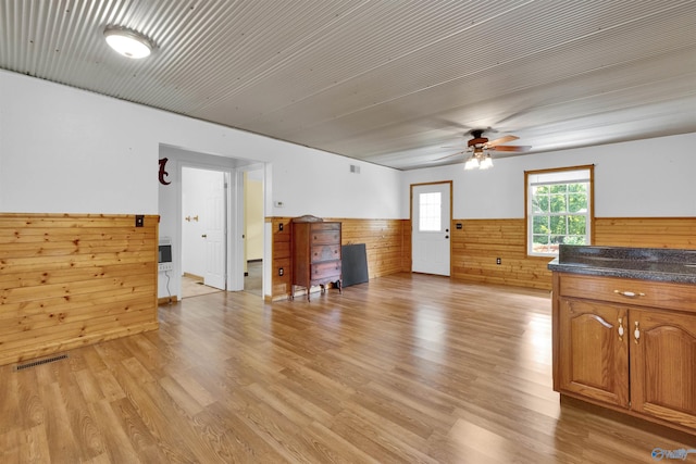 1073 6th St S, Sylvania, AL 35988 - unfurnished living room with a wainscoted wall, ceiling fan, wood walls, and light wood-style flooring