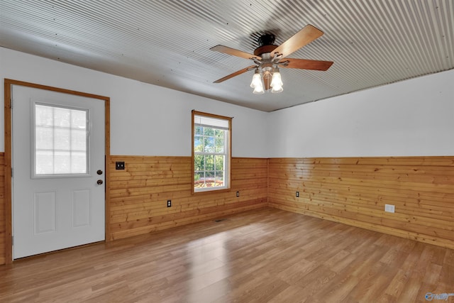 1073 6th St S, Sylvania, AL 35988 - empty room featuring a wainscoted wall, ceiling fan, wood walls, and light wood-type flooring
