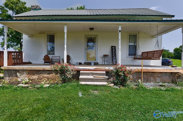 rear view of property with a porch and a lawn