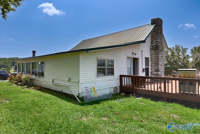 back of house featuring a wooden deck and a lawn