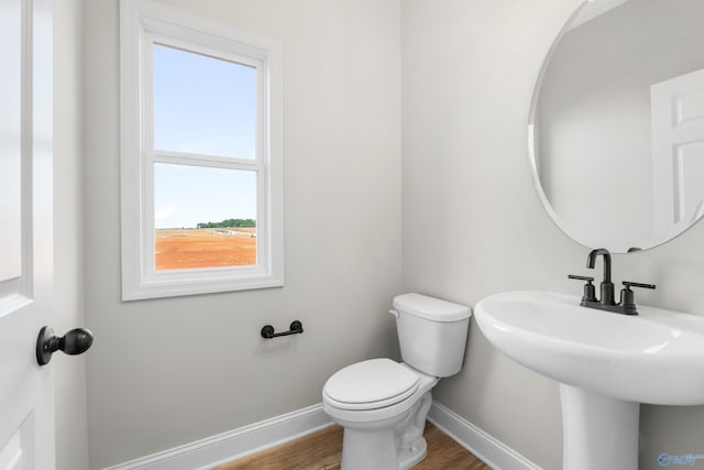 bathroom featuring wood-type flooring and toilet