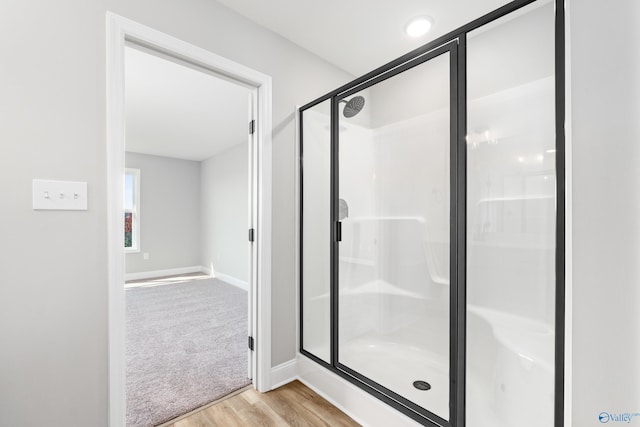 bathroom featuring hardwood / wood-style floors and a shower with shower door