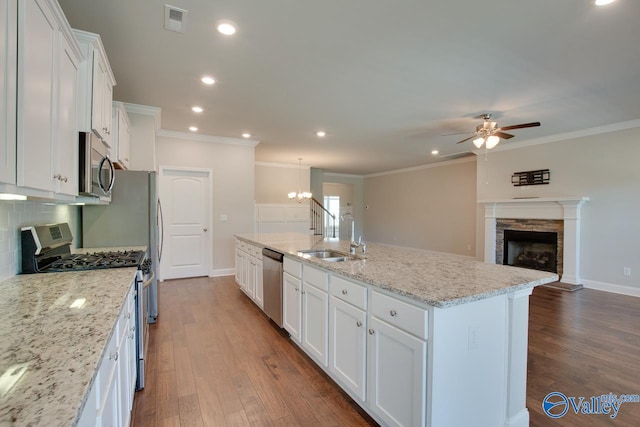 kitchen featuring dark hardwood / wood-style flooring, tasteful backsplash, a kitchen island with sink, white cabinetry, and stainless steel appliances