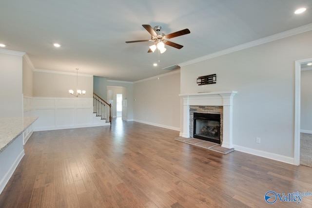 unfurnished living room with ceiling fan with notable chandelier, crown molding, light hardwood / wood-style flooring, and a fireplace