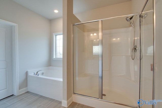 bathroom with tile patterned flooring and separate shower and tub