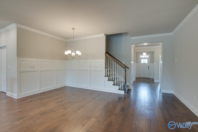 foyer with an inviting chandelier, dark wood-type flooring, and ornamental molding