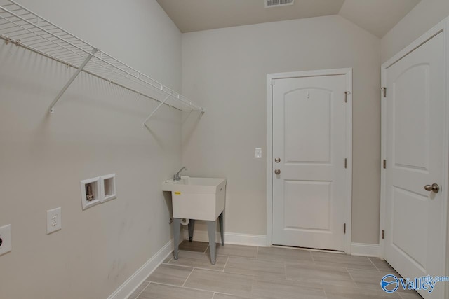 washroom featuring washer hookup, electric dryer hookup, and light tile patterned floors