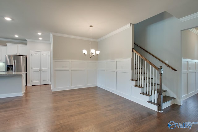 unfurnished dining area with a notable chandelier, crown molding, and hardwood / wood-style floors