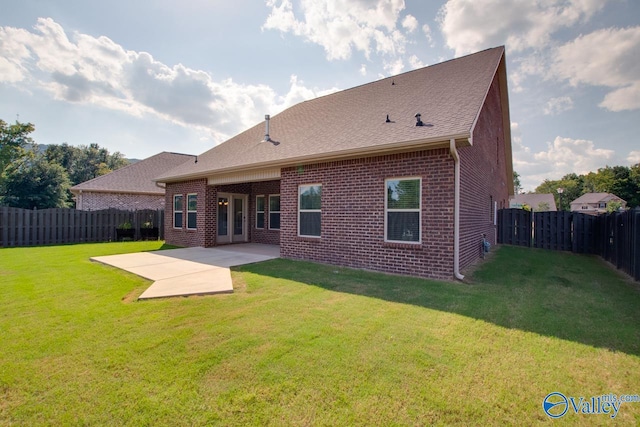 back of house with a lawn and a patio