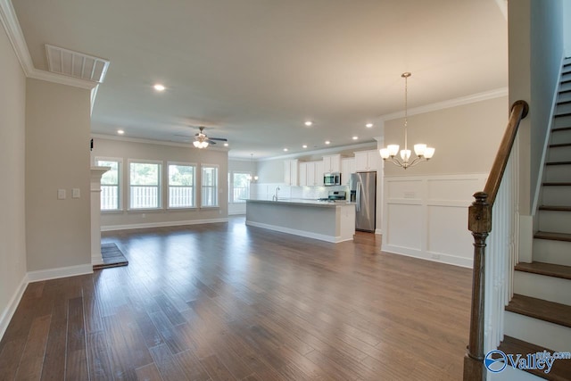 unfurnished living room with sink, crown molding, ceiling fan with notable chandelier, and hardwood / wood-style flooring