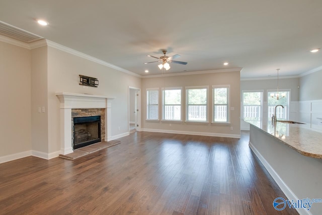 unfurnished living room featuring ornamental molding, dark hardwood / wood-style floors, and a stone fireplace