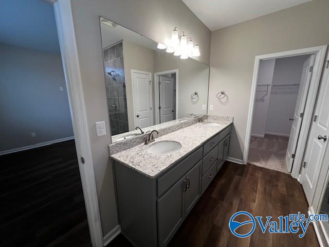 bathroom with hardwood / wood-style floors, vanity, and a notable chandelier