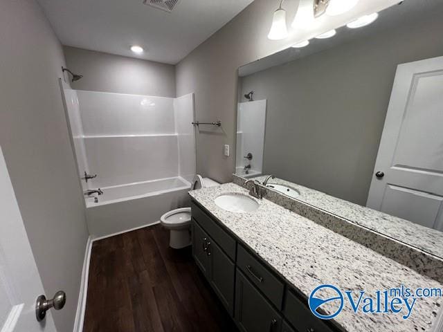 full bathroom with hardwood / wood-style flooring, vanity, toilet, and shower / washtub combination