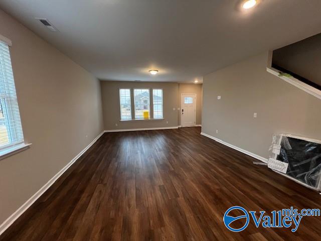 unfurnished living room featuring dark wood-type flooring