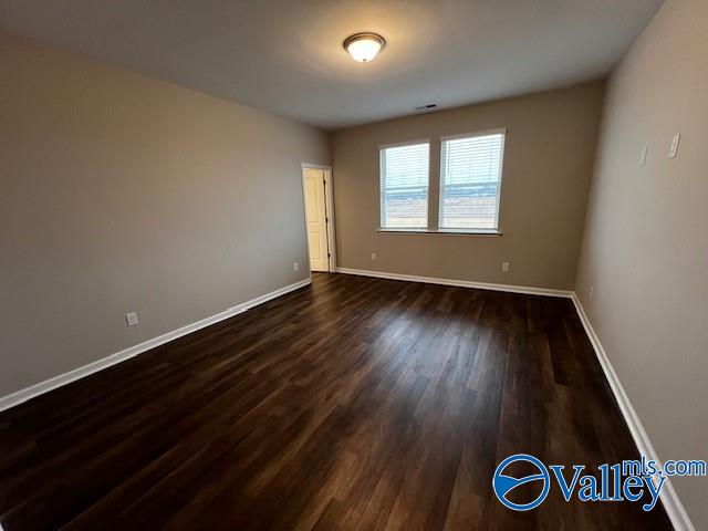 empty room with dark hardwood / wood-style floors