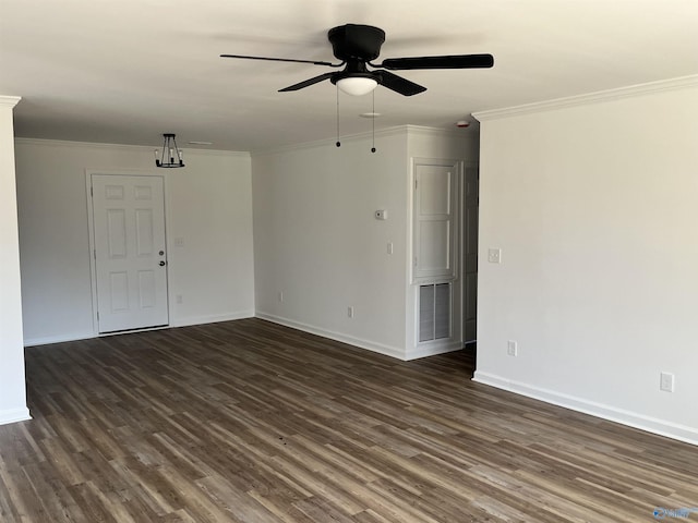 empty room with visible vents, dark wood-type flooring, ceiling fan, baseboards, and ornamental molding