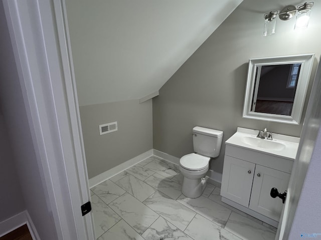 bathroom with lofted ceiling, toilet, and vanity