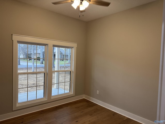 spare room with dark hardwood / wood-style floors and ceiling fan