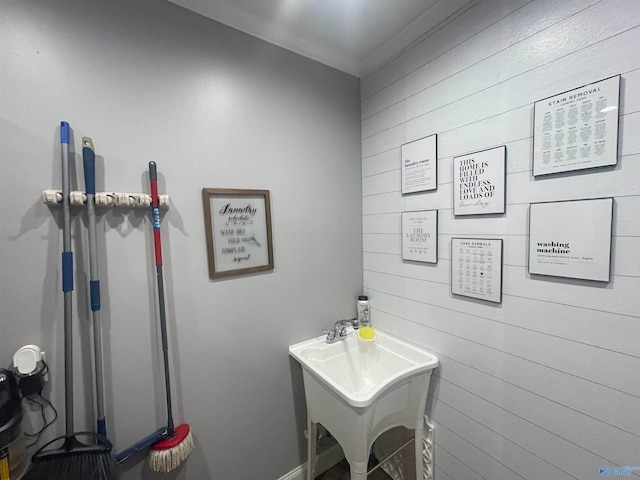 bathroom featuring wood walls and sink