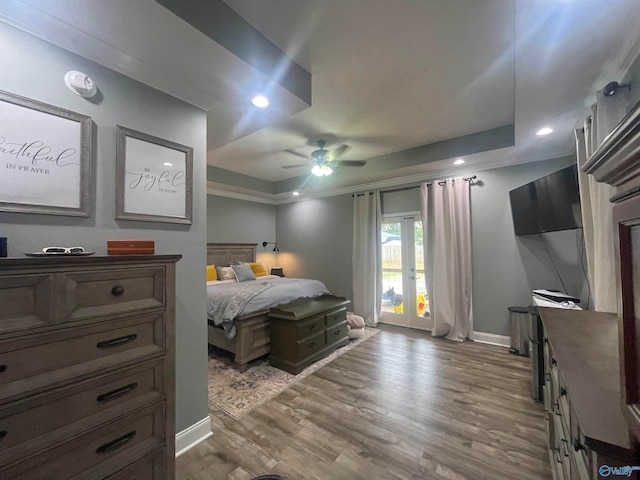 bedroom featuring ceiling fan, a tray ceiling, and hardwood / wood-style flooring