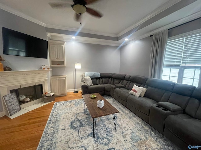 living room with hardwood / wood-style floors, ceiling fan, and ornamental molding