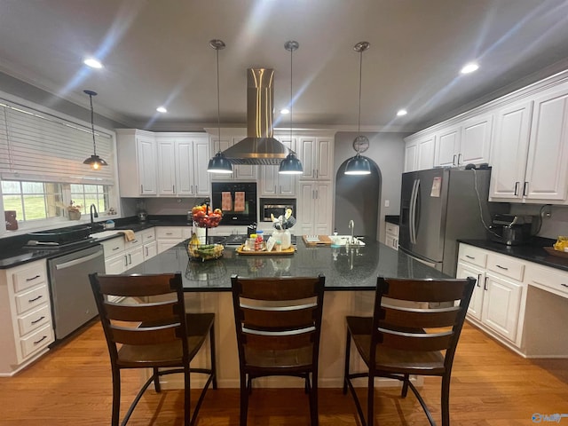 kitchen featuring a center island, white cabinetry, decorative light fixtures, and island range hood