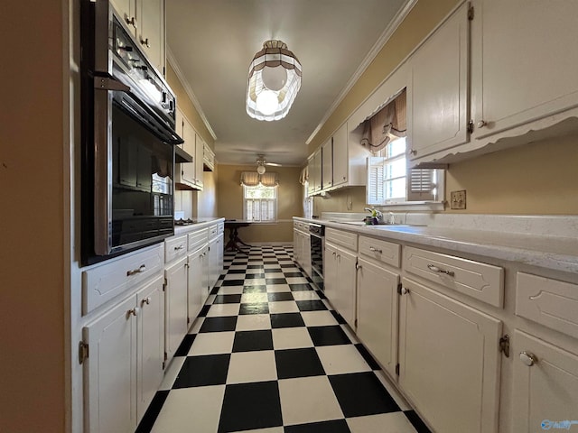 kitchen with black appliances, sink, ceiling fan, white cabinets, and ornamental molding