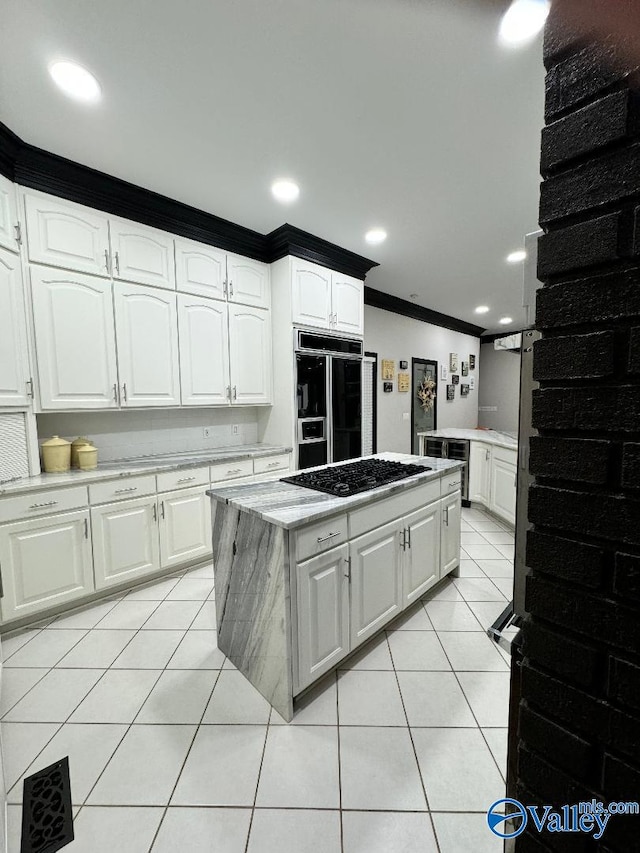 kitchen with white cabinetry, paneled refrigerator, black gas stovetop, and light tile patterned flooring