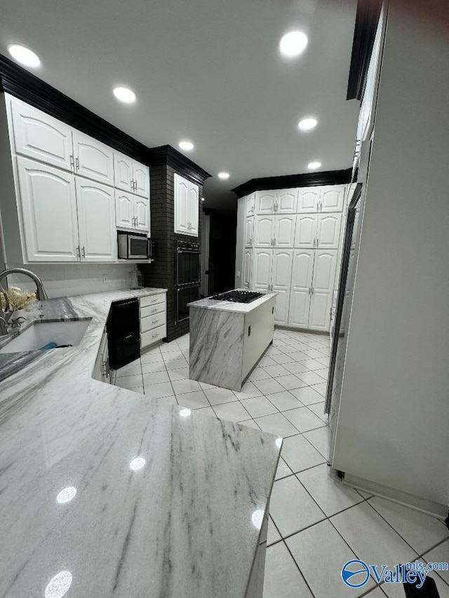 kitchen with sink, white cabinetry, refrigerator, light tile patterned floors, and a kitchen island