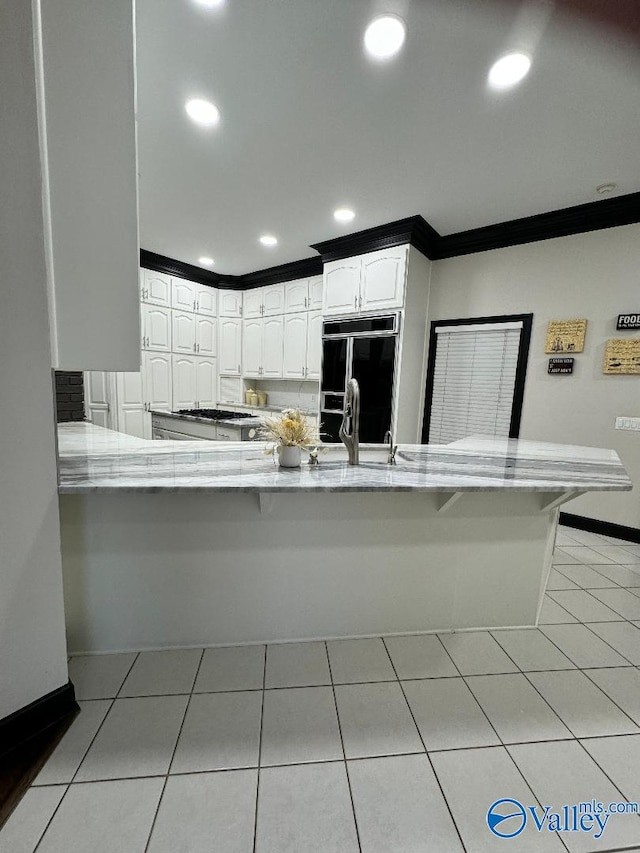 kitchen featuring white cabinetry, sink, paneled refrigerator, and kitchen peninsula