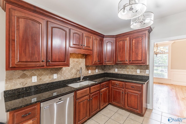 238 Riverwalk Trl, New Market, AL 35716 - kitchen with stainless steel dishwasher, a chandelier, light tile patterned floors, dark stone countertops, and a wainscoted wall