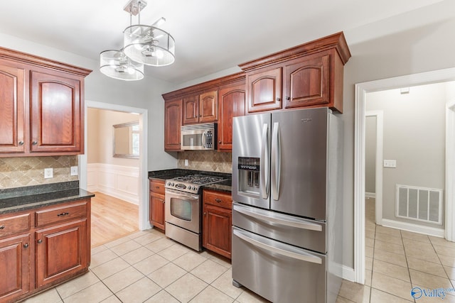 238 Riverwalk Trl, New Market, AL 35716 - kitchen with appliances with stainless steel finishes, light tile patterned floors, a chandelier, and tasteful backsplash