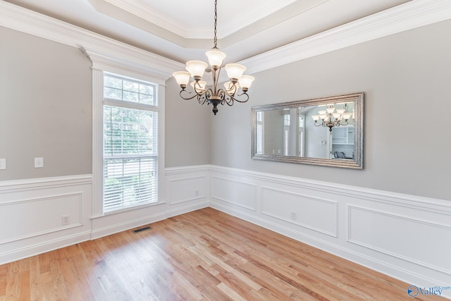238 Riverwalk Trl, New Market, AL 35716 - empty room featuring a chandelier, light wood-type flooring, a wainscoted wall, crown molding, and a raised ceiling