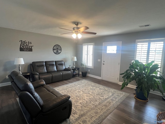 living room with ceiling fan and dark wood-type flooring