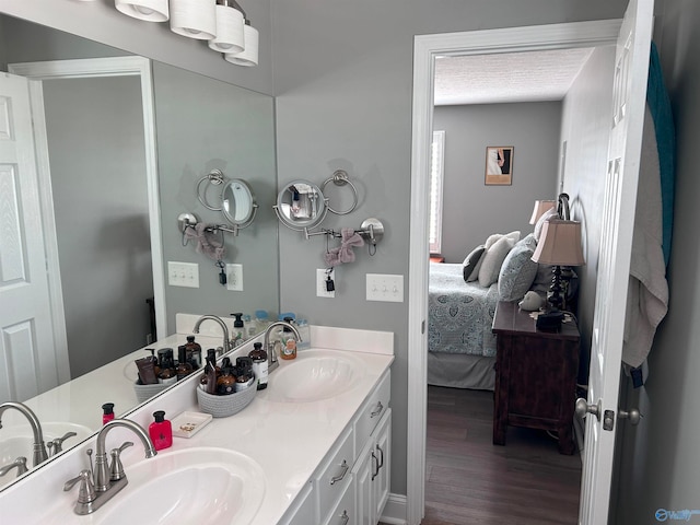 bathroom with dual vanity and wood-type flooring