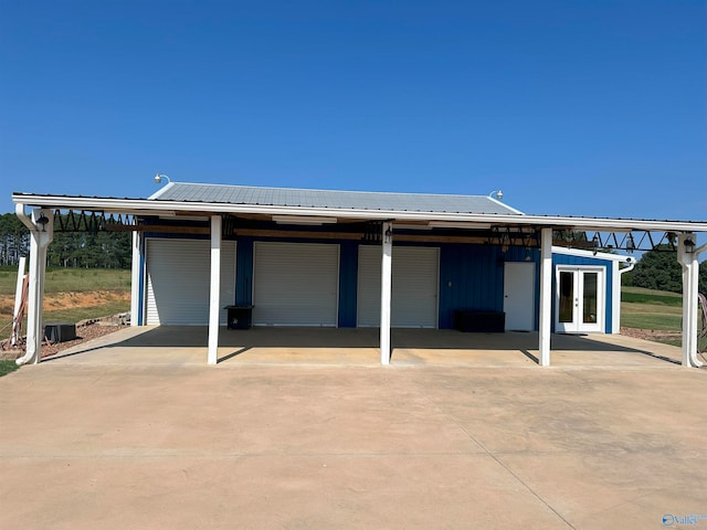 rear view of property featuring a carport and french doors