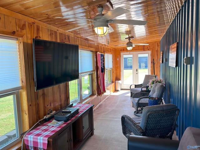 interior space featuring ceiling fan, wood walls, wood ceiling, and a wealth of natural light