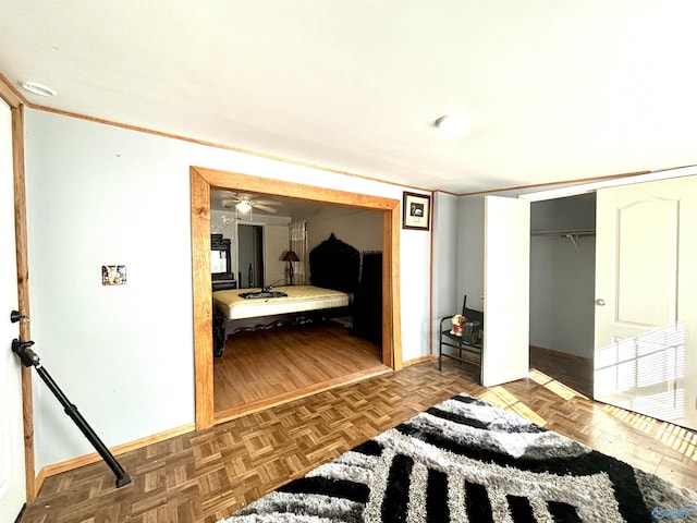 bedroom with a closet, parquet floors, and baseboards