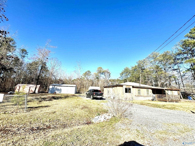 view of side of property featuring driveway and an outbuilding