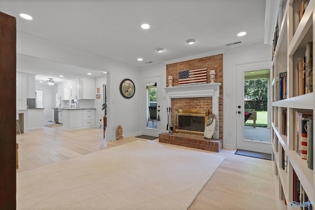 24961 Capshaw Rd, Athens, AL 35613 - unfurnished living room featuring light wood-type flooring, a fireplace, crown molding, and recessed lighting