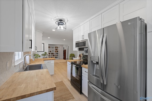 24961 Capshaw Rd, Athens, AL 35613 - kitchen featuring stainless steel appliances, wooden counters, white cabinets, recessed lighting, and a textured ceiling