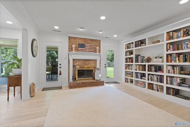 24961 Capshaw Rd, Athens, AL 35613 - living area with wood finished floors, healthy amount of natural light, a brick fireplace, ornamental molding, and recessed lighting